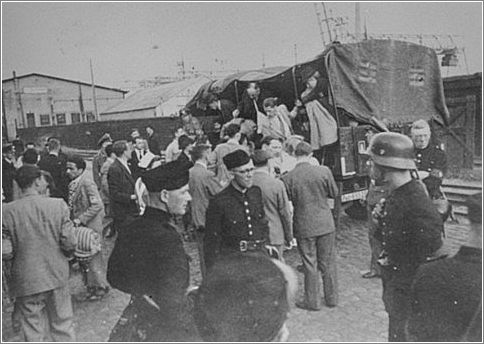 Jews seized in their homes are brought by truck to the Muiderpoort railroad station in the Polderweg district